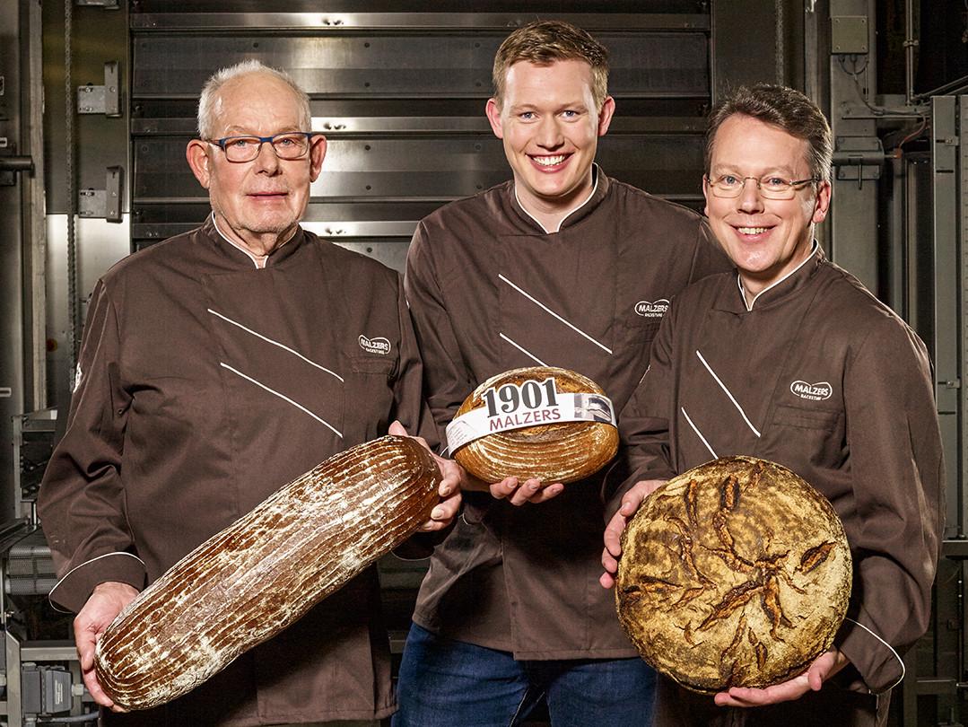 Herbert Wortmann, Christian und Hans-Joachim Scherpel halten Malzers Brote in den Händen