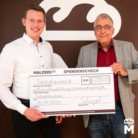 Christian Scherpel hält Spendencheck in Händen